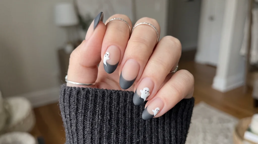 Matte charcoal French tip nails with glossy 3D white ghost accents on short nails